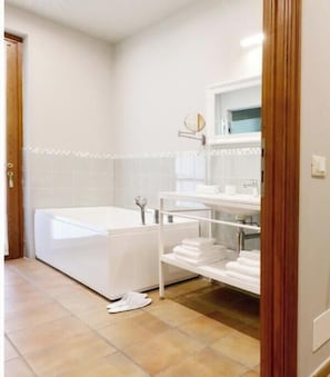 A modern bathroom with a bathtub, a vanity with a mirror, and a towel rack. - The Seven Ways - Maple Apartment with Jacuzzi and Large Porch (Piemonte)