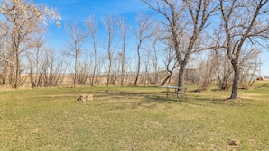 A park with a bench, trees, and a clear sky. - Peaceful Prairie Living! Rural Willow City Apt (Willow City)
