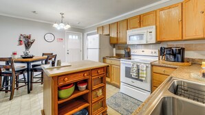 A kitchen with wooden cabinets, a white refrigerator, a microwave, and a stove. - Spacious Yard! Family Home, 10 Mi to Fort Bragg (Fayetteville)