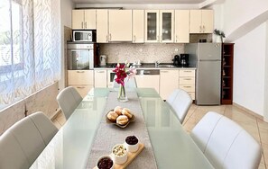 Eine moderne Küche mit Esstisch, Stühlen und einem Blumenstrauß.