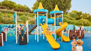 Zona de juegos infantiles con toboganes y estructuras para escalar.