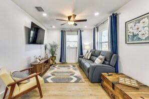 A living room with a sofa, armchair, wooden coffee table, and a ceiling fan. - Work & Play in Palmetto! Pet-Friendly Home w/ Yard (Palmetto)