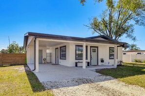 A modern single-story house with a covered porch, a fenced yard, and a large tree. - Work & Play in Palmetto! Pet-Friendly Home w/ Yard (Palmetto)