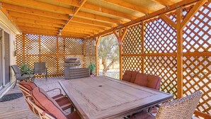 An outdoor patio with a wooden table and wicker chairs, surrounded by a wooden lattice fence. - 7 Miles to Roosevelt Lake! Mtn-View Family Escape (Tonto Basin)