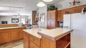 A kitchen with wooden cabinets, a white refrigerator, and a countertop. - 7 Miles to Roosevelt Lake! Mtn-View Family Escape (Tonto Basin)