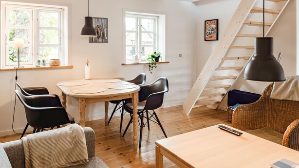 A cozy dining area with a wooden table, black chairs, and a hanging pendant light. - 2 bedroom lovely apartment in Kolind (Kolind)
