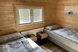 A cabin with two beds, a window, a radiator, and a small table with lamps. - Holiday home in Menaldum with swimming pool (Menaldum)