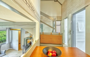 Ein modernes Interieur mit einem Holztisch, einer Schüssel Äpfel und Blick ins Freie.