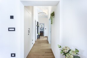 A modern hallway with a wooden floor, a circular mirror, and a hanging plant. - Completely new!!!! Exclusive villa with 4 bedrooms and a private 32 m² pool (ŽMINJ)