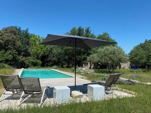 Ein Pool mit Liegestühlen und einem Sonnenschirm.