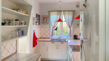 Coffee/tea maker, fridge, stovetop, cookware/dishes/utensils