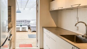 Une cuisine de taille réduite, équipée d’un évier, de placards et d’un plancher en bois.