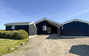 A two-story building with a gravel driveway and a small garden area. - Beautiful home in Fårevejle with house sea view (Fårevejle)