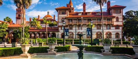 A historic building with a fountain in the courtyard.