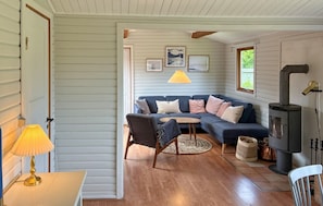 A cozy living room with a sofa, a small table, a lamp, and a fireplace. - 3 bedroom cozy home in Kalundborg (Kalundborg)