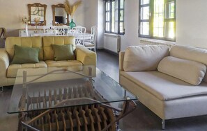A living room with a glass coffee table, two sofas, a dining area with a white table and chairs, and large windows with natural light. - Beautiful home in Alcala la Real (Alcala la Real)