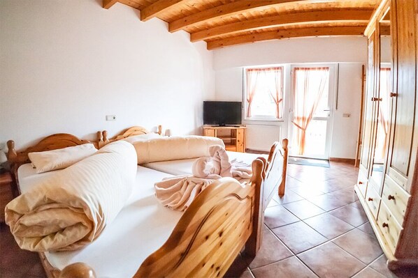 Ein Schlafzimmer mit einem hölzernen Bett, einem Fernseher und einem Kleiderschrank.