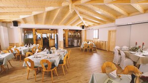A spacious hall with wooden floors and high ceilings, tables set for dining, and a stage area. - Butzkamm`s Ferien- & Studiohaus cultivated hospitality in the Sauerland (Wenden)