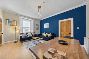 A living room with a sofa set, a coffee table, a dining table, and a chandelier. - Castle Terrace: Stylish Victorian Townhouse in the Heart of Stirling (Stirling)