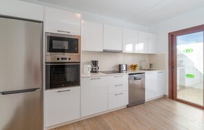 A modern kitchen with white cabinets, a built-in oven, a microwave, a coffee maker, and a dishwasher. - Nice home in Lanzarote with private swimming pool, can be inside or outside (Lanzarote)