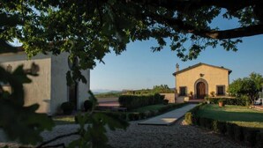 A building with a gravel pathway leading to a door, surrounded by greenery and a clear sky. - Casale di Valle - Historic House in the Heart of Chianti (Toscana)
