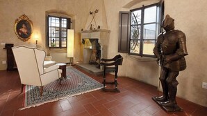 A room with a fireplace, a statue, a chair, and a window with a view. - Casale di Valle - Historic House in the Heart of Chianti (Toscana)