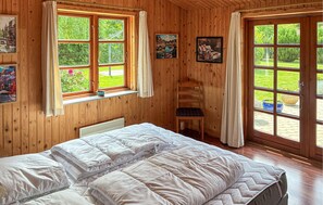 A wooden-paneled room with a bed, two windows, and a door. - 3 bedroom beautiful home in Eskebjerg (Eskebjerg)