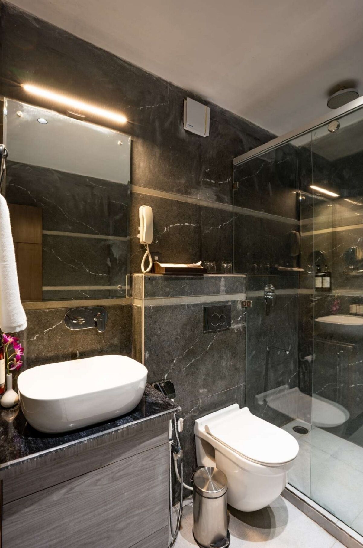 Een douche, designer toiletartikelen, een haardroger, badjassen
