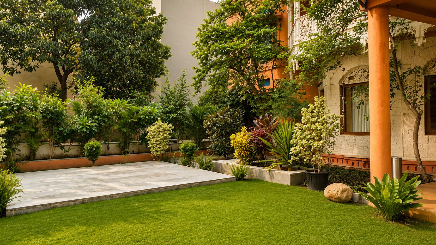 Um pátio com área pavimentada, gramado exuberante e diversas plantas.