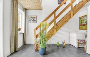 A room with a wooden staircase, a potted plant, a radiator, and a framed picture on the wall. - 5 bedroom lovely home in Sydals (Sydals)