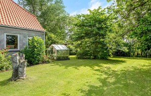 A house with a red-tiled roof, a greenhouse, and a well-maintained lawn. - 5 bedroom lovely home in Sydals (Sydals)