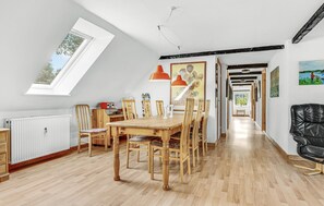 A dining area with a wooden table and chairs, a radiator, and a skylight. - 5 bedroom lovely home in Sydals (Sydals)