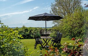 An outdoor patio with a table and chairs, surrounded by greenery and a view of the landscape. - Lovely home in Sydals with WiFi (Sydals)