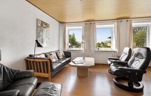 A living room with a sofa, two chairs, a coffee table, and a window with curtains. - Lovely home in Sydals with WiFi (Sydals)