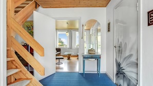 A staircase leading to a room with a blue carpet, a wooden ceiling, and a door with a floral painting. - Lovely home in Sydals with WiFi (Sydals)