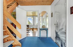 A staircase leading to a room with a blue carpet, a wooden ceiling, and a door with a floral painting. - Lovely home in Sydals with WiFi (Sydals)