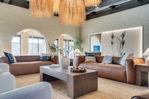 Ein modernes Wohnzimmer mit einer Sofagarnitur, einem Couchtisch und einem großen abstrakten Gemälde.