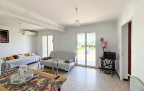 Ein Zimmer mit einem Bett, einem Tisch mit einer dekorativen Schale, einer Couch und einem kleinen Tisch mit einem Blumenstrauß.