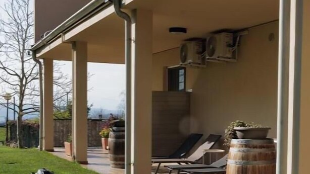 A covered outdoor area with a lawn, a barrel, and lounge chairs. - The Seven Ways - Birch Apartment with Relaxing Porch (Piemonte)