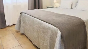 Una habitación de hotel con una cama, una mesita de noche y una lámpara.