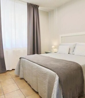 Ein Hotelzimmer mit Bett, Nachttisch und Lampe.
