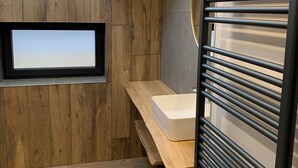 A modern bathroom with a skylight, wooden wall paneling, a built-in sink, and a towel rack. - Les Privilèges family home in the heart of nature, 5 minutes from the town center (Gérardmer)