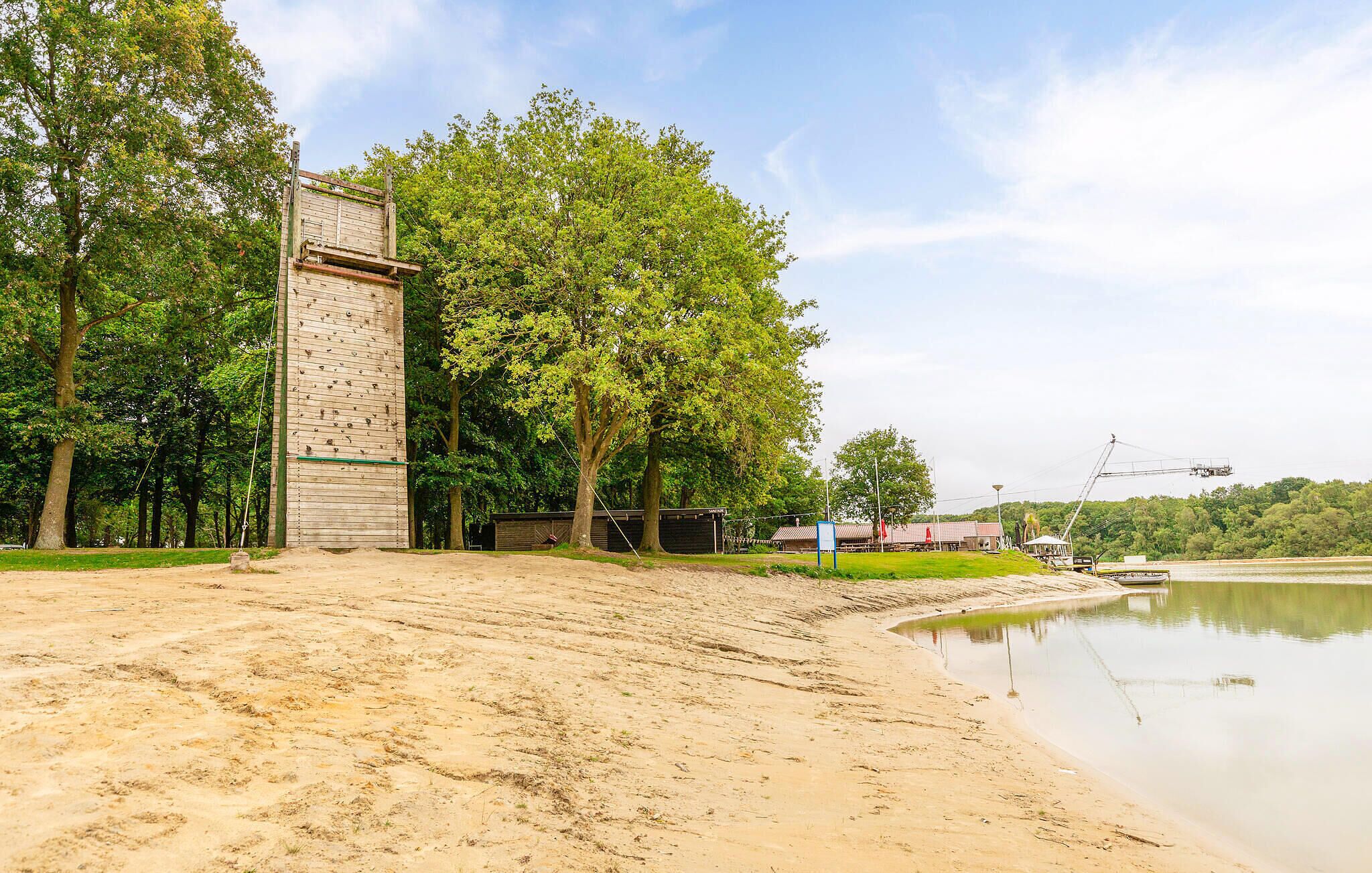 A riverside area with a wooden structure, trees, and a calm water body.