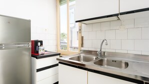 A modern kitchen with a stainless steel refrigerator, a double sink, and a window with a view of the outside. - Apartment 'Casa Nerea' with Balcony and Wi-Fi (Dorgali)