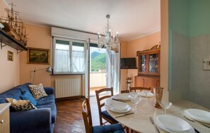 Ein Essbereich mit einem für vier Personen gedeckten Tisch, einer Kandelaber und Blick auf Berge durch das Fenster.