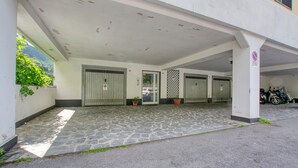 A building with a covered entrance, multiple doors, and a parking area with motorcycles. - 2 bedroom lovely apartment in Genova (Genova)