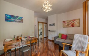 Ein Essbereich mit Holztisch und Stühlen, einer Couch und einem Sessel mit Streifenmuster.