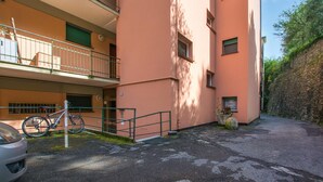 Ein mehrstöckiges Gebäude mit Balkonen, einem Fahrrad und einer Steinmauer.