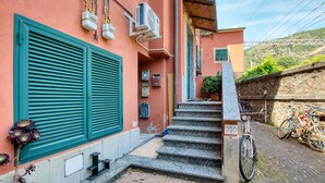 Eine enge Treppe führt zu einem Hauseingang, vor dem ein Fahrrad abgestellt ist.