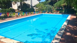 A rectangular swimming pool with a tiled edge, surrounded by a brick deck. - Cozy home in Caltagirone with WiFi (Caltagirone)